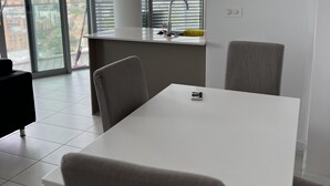 Eine moderne Küche mit weißer Arbeitsplatte, einem Spülbecken und einem Fenster mit Jalousien.