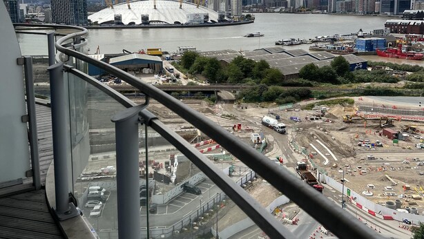 Blick vom Balkon auf eine Baustelle mit Stadtansicht im Hintergrund.