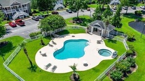 Una propiedad residencial con piscina, terraza cubierta y patio cercado.