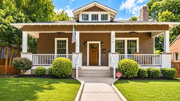 A two-story house with a front porch, a mailbox, and a stop sign. - Lovely Home & Guest Suite. Walk to City & Stadium. (Charlotte)