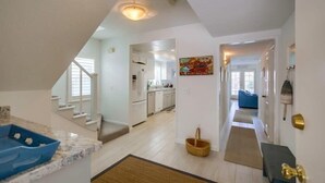 A spacious kitchen with white cabinets, a blue countertop, and a wooden floor. - South Mission Beach Gem, Steps to Bay, Dual Patios (San Diego)