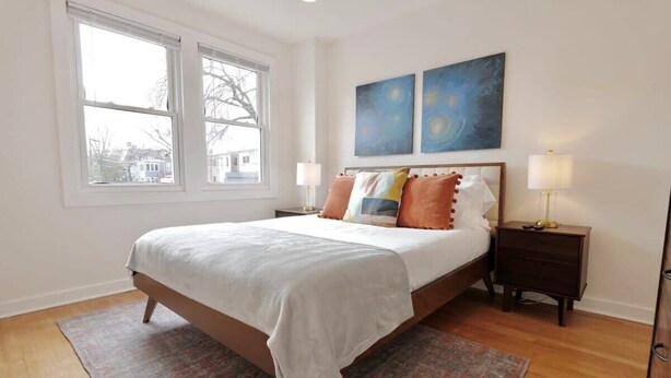 A bedroom with a bed, two bedside tables, a window, and two paintings on the wall. - Meridian Row | Sleeps 7 | Off St Parking! (Washington)
