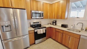 A modern kitchen with stainless steel appliances, wooden cabinets, a built-in oven, and a large window. - Meridian Row | Sleeps 7 | Off St Parking! (Washington)