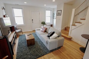 A living room with a sofa, coffee table, and a staircase. - Meridian Row | Sleeps 7 | Off St Parking! (Washington)