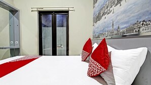 Una habitación de hotel con una cama, una puerta y un mural con vistas a la ciudad.