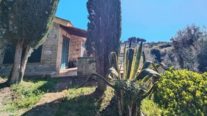 A stone building with green shutters, surrounded by tall cypress trees and a clear blue sky. - Residence con piscina a Guardistallo  (Guardistallo)