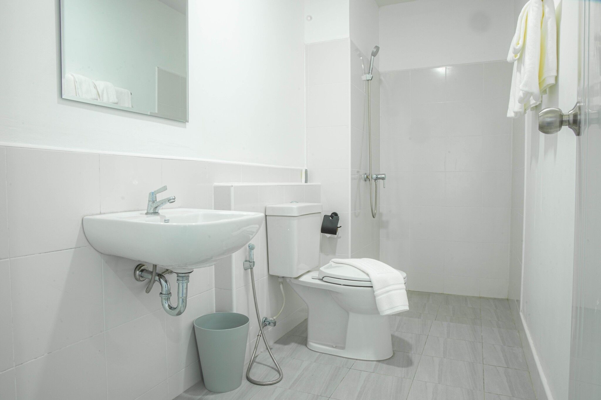 Une salle de bain moderne équipée d’un lavabo, de toilettes et d’une douche.