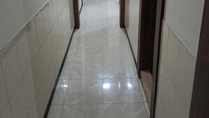 A corridor with tiled walls and floor, leading to a door at the end. - Hotel Orchid (Guwahati)