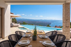 Ein Essbereich mit Blick auf einen Pool und Berge.