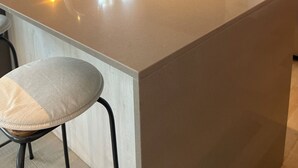 Eine moderne Küche mit Kochinsel, Edelstahlspüle und integrierter Dunstabzugshaube.