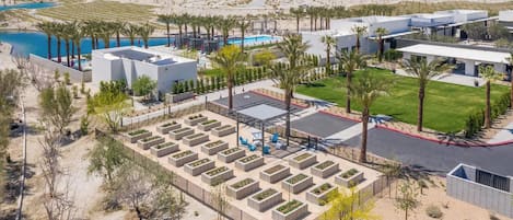 A modern resort with a pool, palm trees, and a desert landscape.
