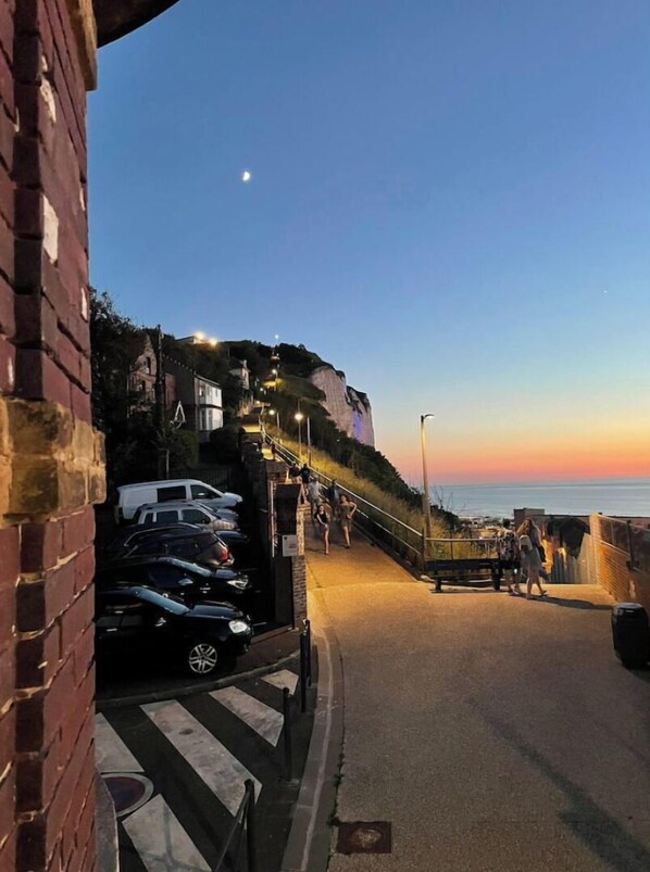 Eine Küstenstraße mit steiler Steigung, die zu einer Klippe mit Blick auf das Meer führt.