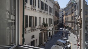 A narrow street with buildings on either side, a few pedestrians, and parked vehicles. - La Residenza Delle Vigne by Wonderful Italy (Genoa)