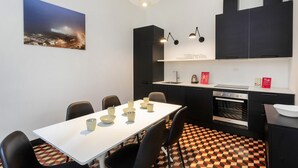 A modern kitchen with a dining table, chairs, and a checkered floor. - La Residenza Delle Vigne by Wonderful Italy (Genoa)