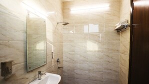 Un baño con ducha de mármol, lavabo y espejo.