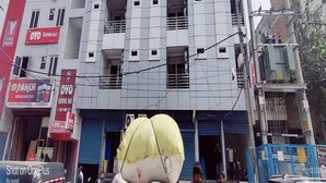 Un edificio de varios pisos con varios balcones y una combinación de locales comerciales y viviendas.