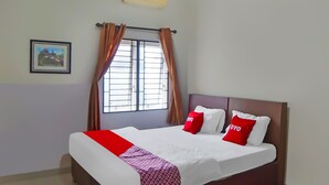 A neatly made bed with a red and white bedspread, two pillows with 'YOYO' branding, and a window with curtains. - Hotel O Medan City Near Sun Plaza Formerly 99 Residence (Medan)