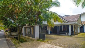 A residential area with a gated entrance, a covered porch, and a paved driveway. - Hotel O Medan City Near Sun Plaza Formerly 99 Residence (Medan)