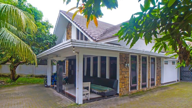 A single-story house with a covered porch, a stone exterior, and a tiled roof. - Hotel O Medan City Near Sun Plaza Formerly 99 Residence (Medan)