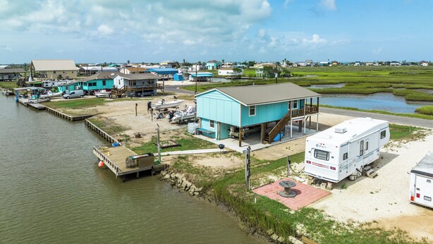 A waterfront property with a dock, a boat, and a mobile home. - Waterfront Bungalow w/ Pier & Amazing Views (Sargent)