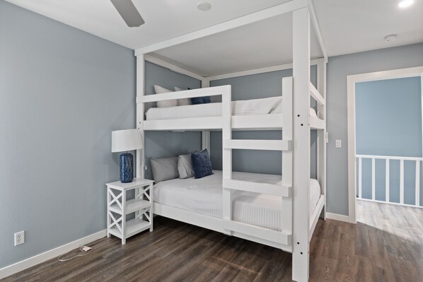 A bunk bed room with a white frame, a nightstand with a lamp, and a blue vase. - Our Cove Retreat - Perfect for Wave-Free Swimming, Tanning & Prime Location Fun! (Lake Ozark)