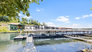 A waterfront property with a dock, a house with a green roof, and a building with a modern design.