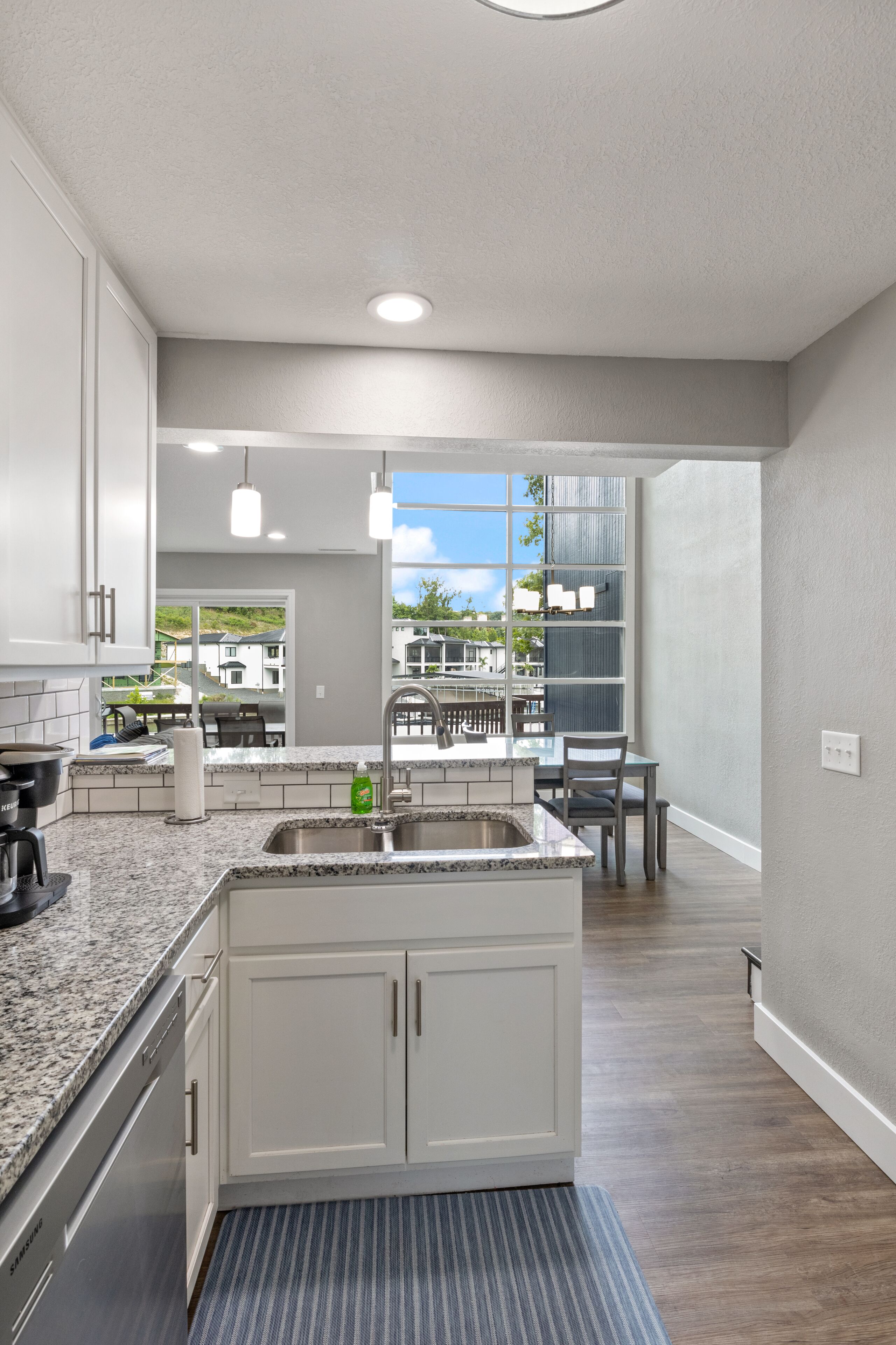 A modern kitchen with granite countertops, white cabinetry, and a large island.