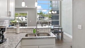 A modern kitchen with granite countertops, white cabinetry, and a large island.