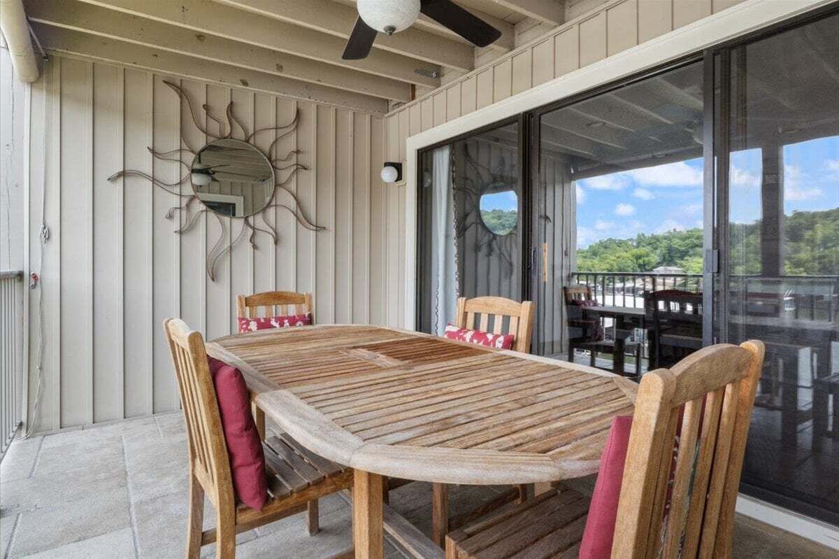 Un tavolo in legno con quattro sedie, una ventola a soffitto e un elemento decorativo a forma di sole sulla parete.