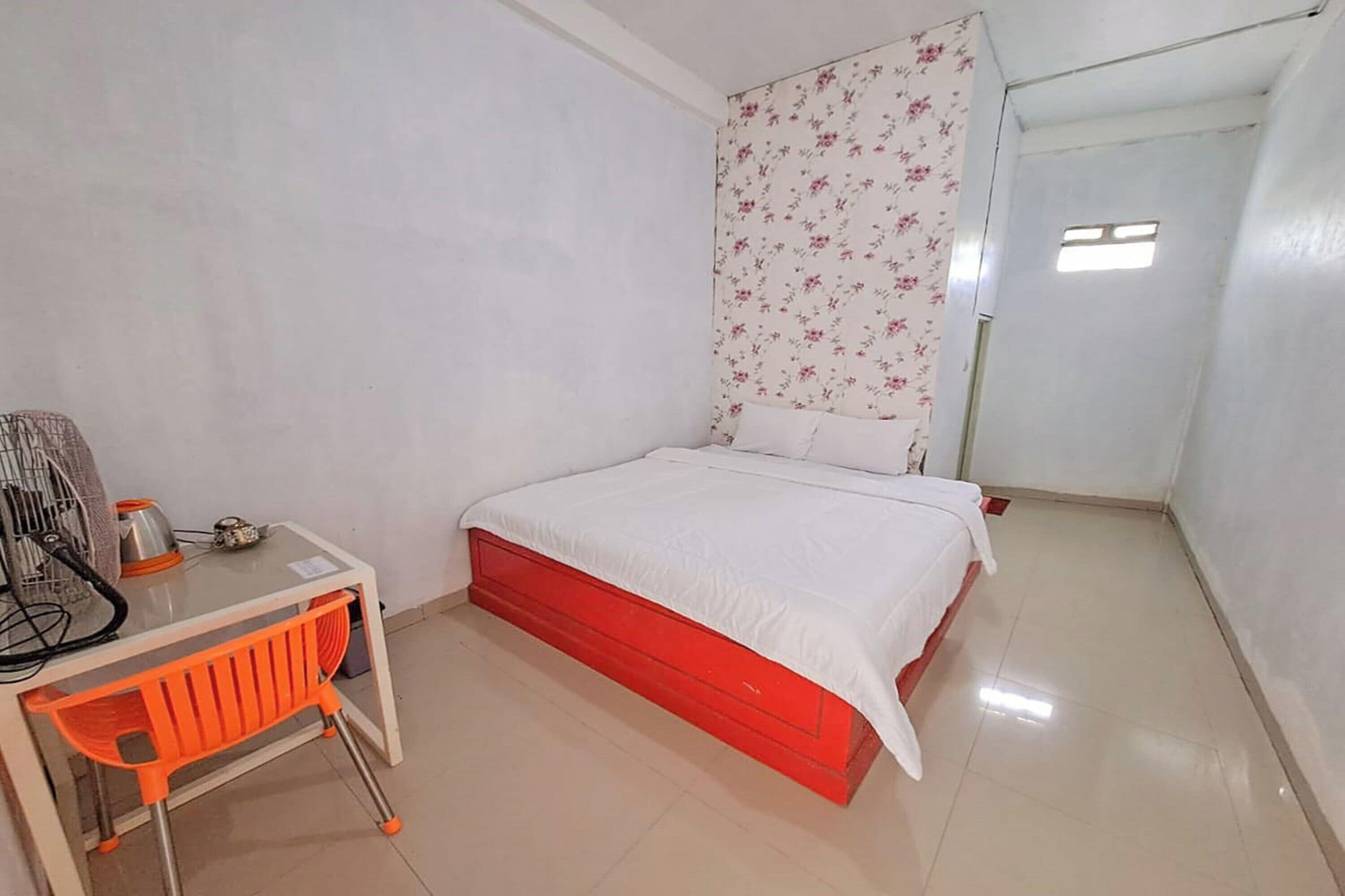 A bedroom with a bed, a desk, and a radiator.