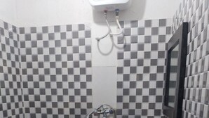 A small bathroom with a checkered tile pattern, a toilet, a sink, and a mirror. - Tega Suites Ikeja (Lagos)