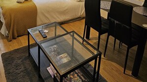 Une pièce confortable avec un lit, un canapé, une table à manger et un tableau accroché au mur.