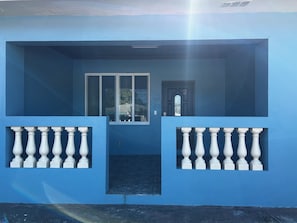 A blue building with a balcony, a door, and a window. - Premium One Bedroom Unit Within Walking Distance to Fish Fry and Beaches (Nassau)