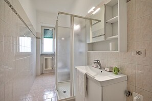 A modern bathroom with a glass-enclosed shower, a white sink, and a mirror above it. - Casa Ojala' in the Center of Alberobello (Alberobello)