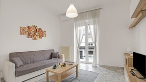 A modern living room with a sofa, coffee table, and artwork on the wall. - Casa Ojala' in the Center of Alberobello (Alberobello)
