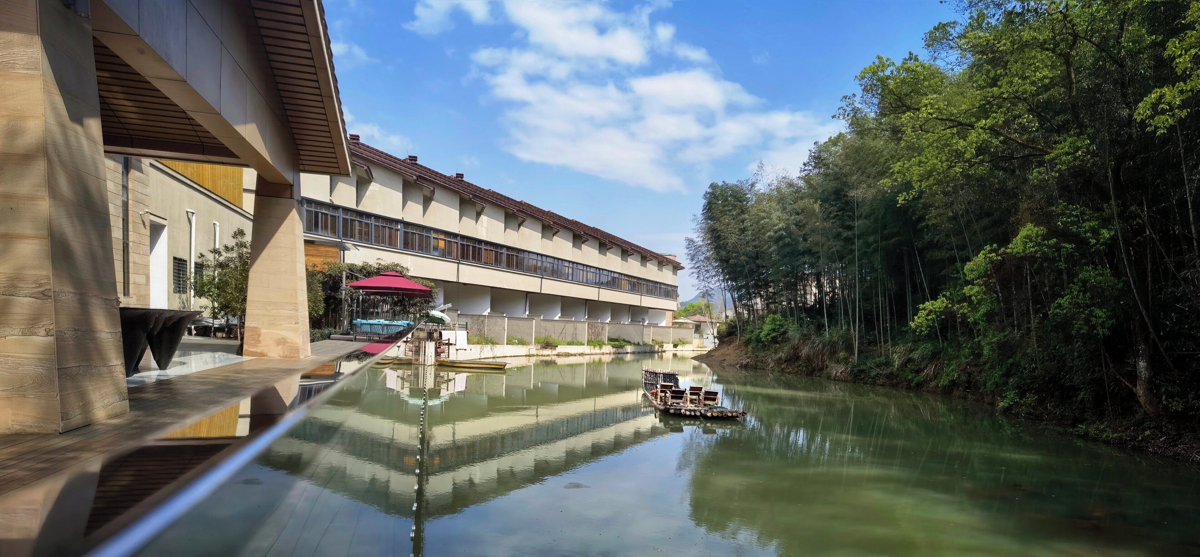 A modern building with a reflective waterway in front.