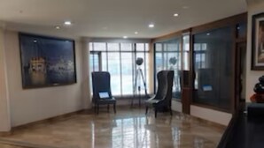 A spacious room with a polished floor, large windows, and a seating area with chairs. - Revking at Hotel Batra  (Ambala)