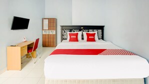 A hotel room with a bed, a desk, a chair, a wardrobe, and a television. - OYO Life 3982 Azka Homestay Syariah (Bandar Lampung)