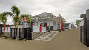 A modern house with a gated entrance, a stone wall, and a red and white color scheme. - OYO Life 3982 Azka Homestay Syariah (Bandar Lampung)