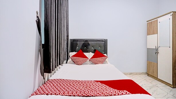 A bedroom with a bed, a wardrobe, and a curtain.