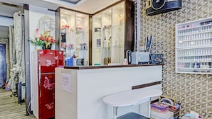 Un salon comprenant un comptoir d’accueil, un miroir et des étagères où sont exposés divers produits.