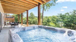 Een hottub onder een houten pergola met uitzicht op een weelderig landschap.