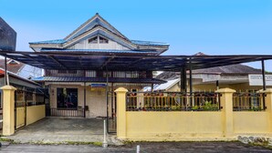 A building with a covered entrance, a gated area, and a sign indicating a bakery.