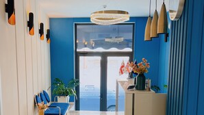 A modern reception area with a blue wall, a chandelier, and a reception desk. - Hotel DownTown Avlabari (Tbilisi)