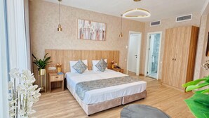 A modern bedroom with a large bed, bedside tables, a round table, and a large window. - Hotel DownTown Avlabari (Tbilisi)