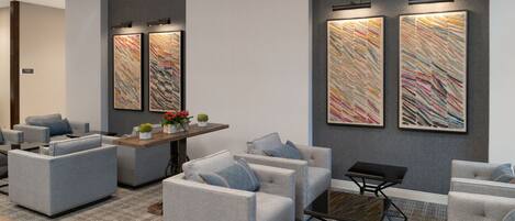 A modern living room with grey sofas, a coffee table, and abstract wall art.