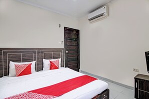 A neatly made bed with white and red bedding, a wooden headboard, and a red throw blanket. - Hotel O Rosela House Syariah (Pekanbaru)