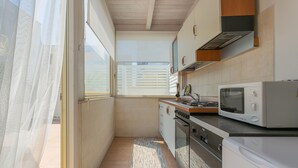 Une cuisine compacte équipée d’un four à micro-ondes, d’une cuisinière, d’un four et d’un lave-vaisselle.