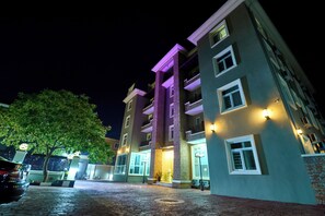 Un hôtel à plusieurs étages doté d’une cour intérieure, de balcons et d’un éclairage extérieur.