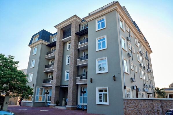 Un immeuble résidentiel à plusieurs étages, doté de balcons, de climatiseurs et d’une façade en briques.